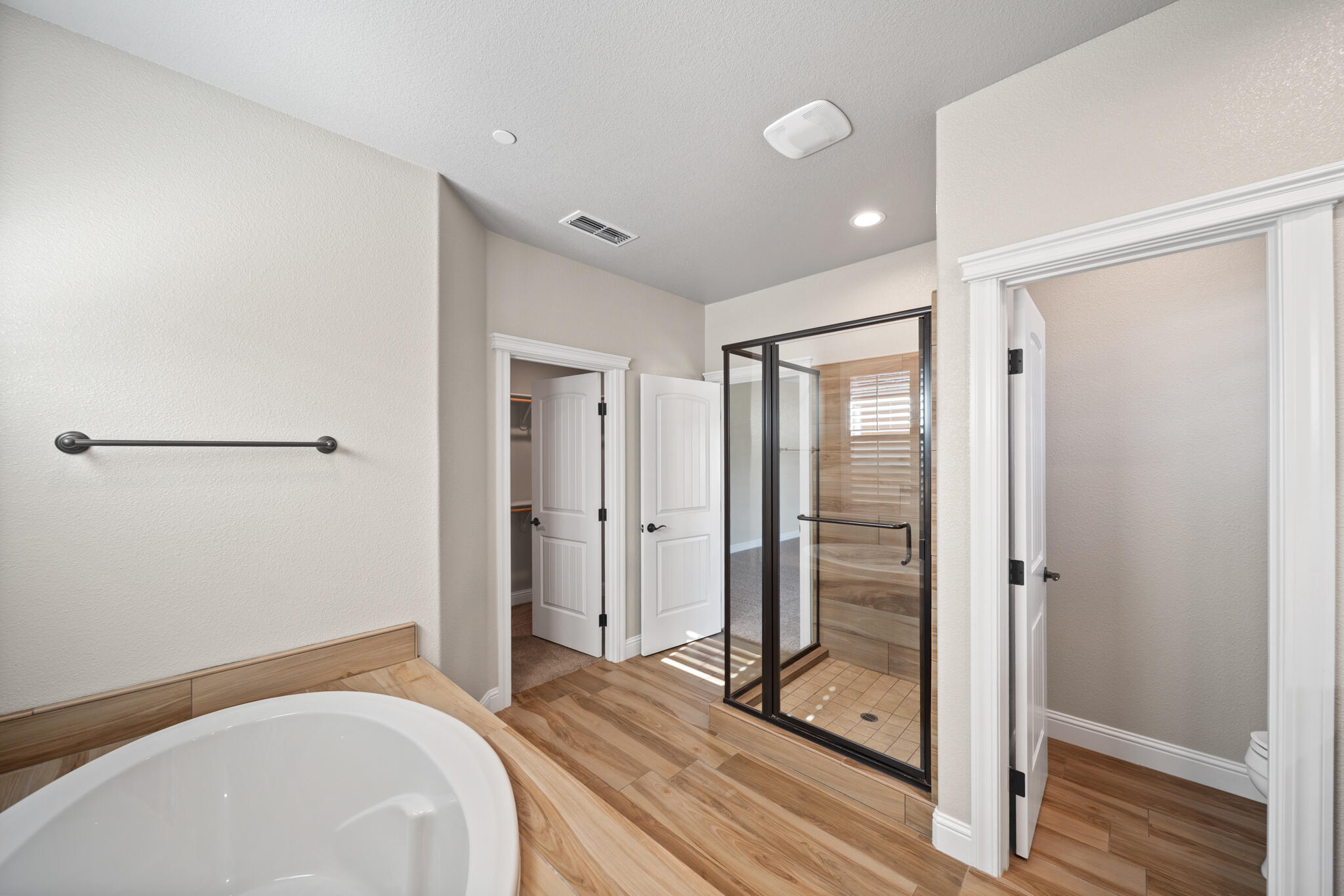 3375 Karuk Avenue Redding, CA 96002 - Photo 19 of 41 a spacious bathroom with a glass shower door and a wooden floor