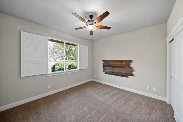 a view of a livingroom with a ceiling fan and window