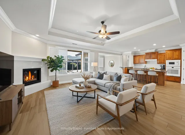 a living room with furniture dining table a fireplace and a kitchen view