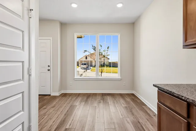 a view of a livingroom with wooden floor and a window