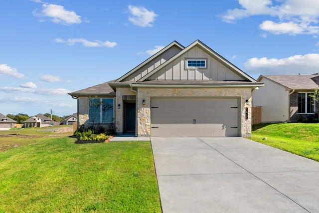 a front view of a house with a yard and trees