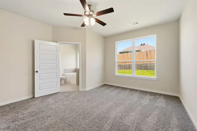 an empty room with closet and a ceiling fan