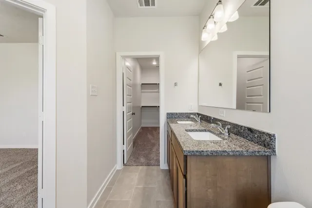 a bathroom with a granite countertop bathtub shower sink and mirror