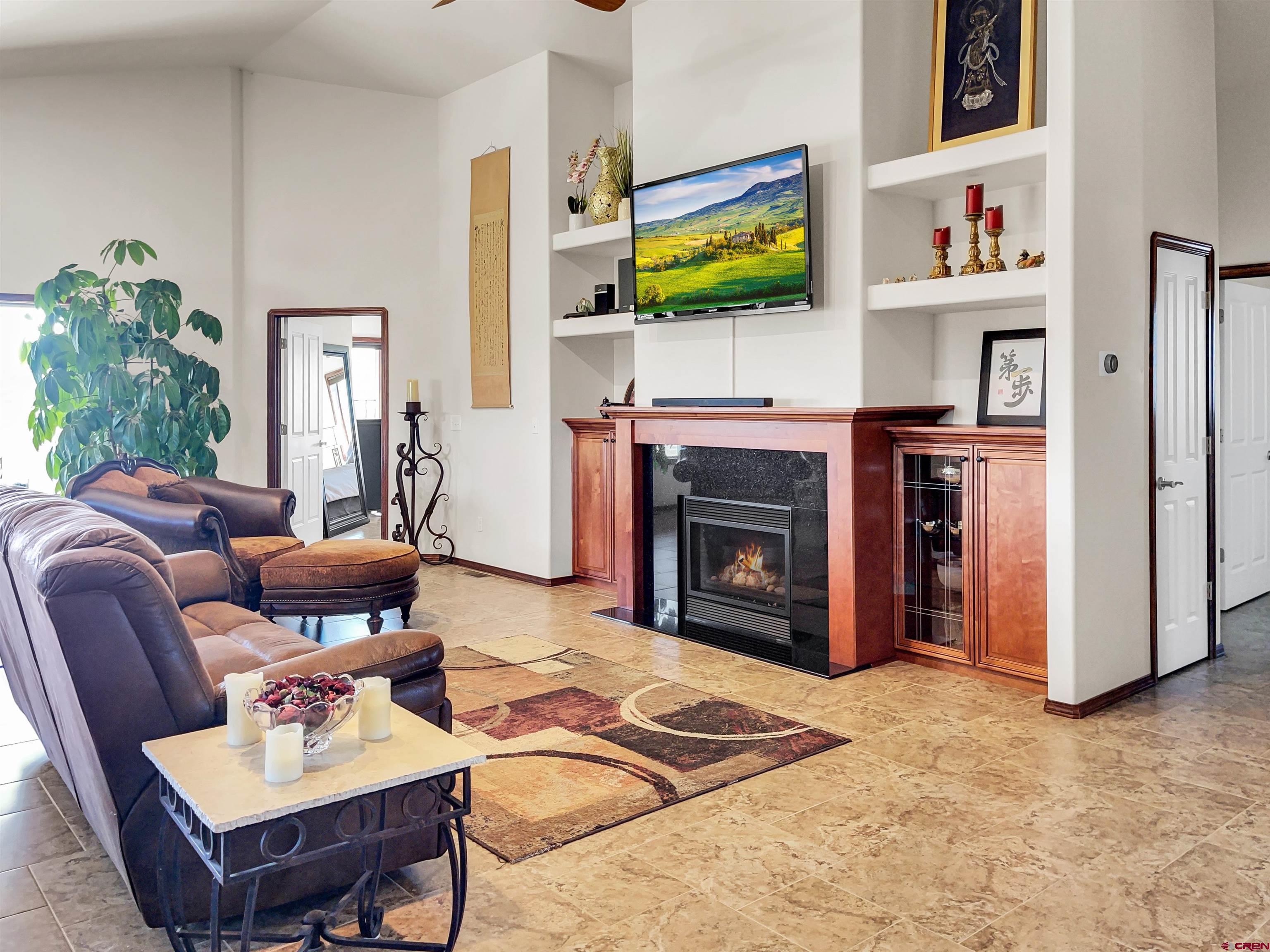 12336 Road 23.25 Loop Cortez, CO 81321 - Photo 15 of 34 a living room with furniture a flat screen tv and a fireplace