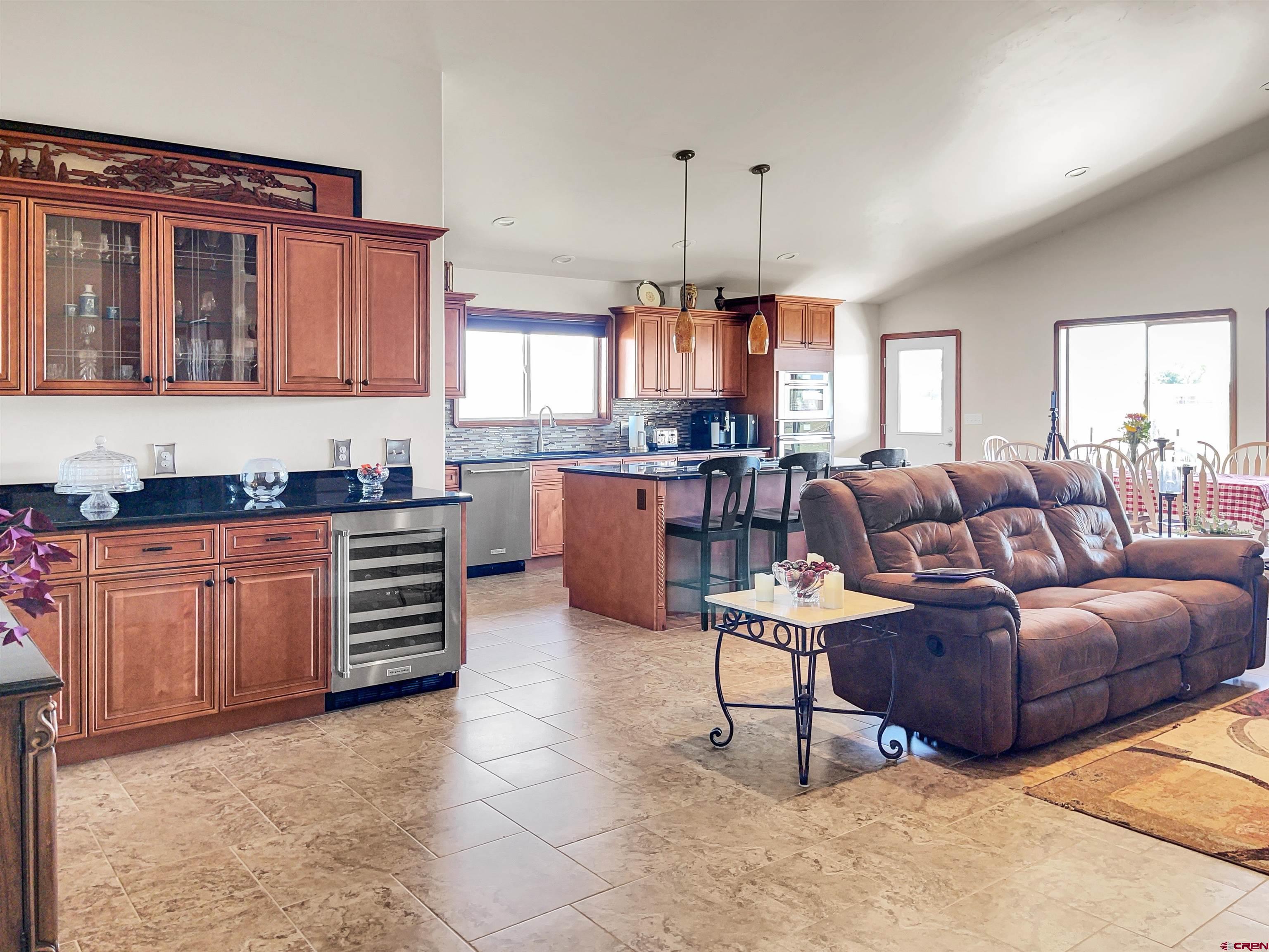 12336 Road 23.25 Loop Cortez, CO 81321 - Photo 18 of 34 a living room with stainless steel appliances kitchen island granite countertop a stove a sink a dining table chair with granite countertops and cabinets