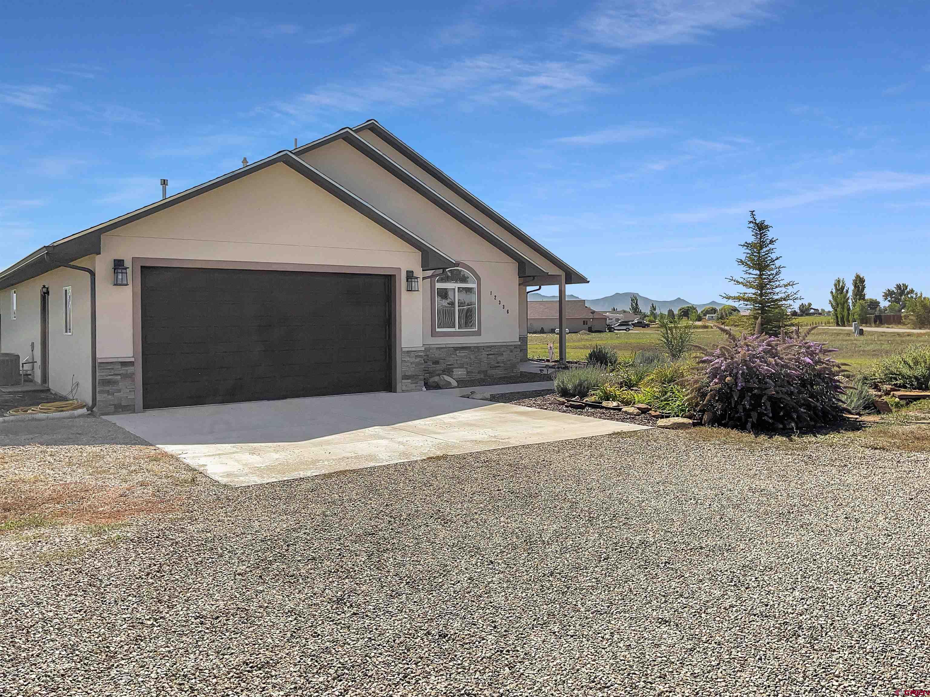 12336 Road 23.25 Loop Cortez, CO 81321 - Photo 3 of 34 a front view of a house with a yard