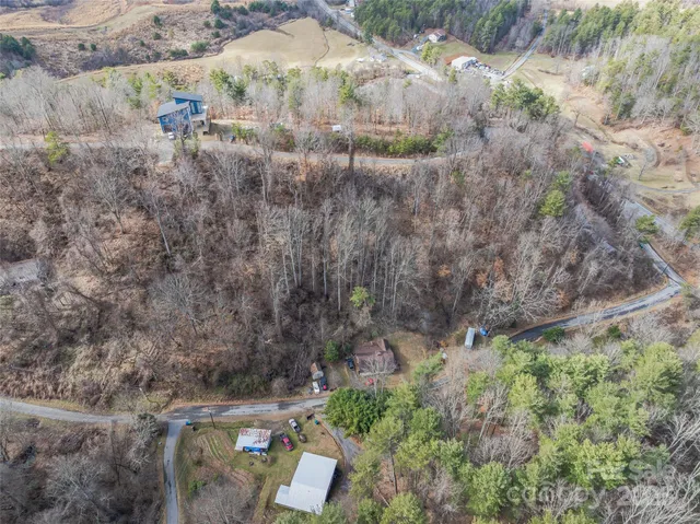 a backyard of a house with a yard and large trees