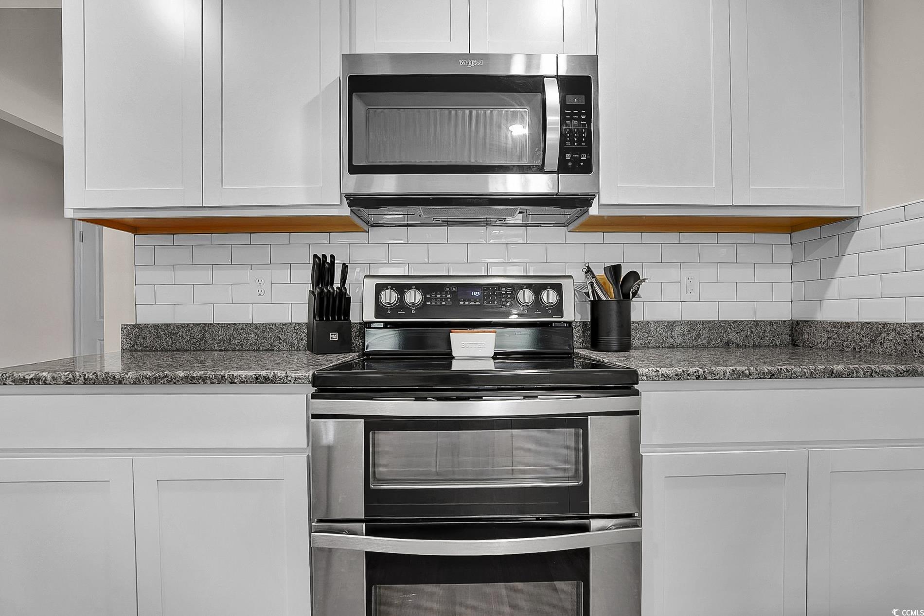 772 Planters Moon Drive Galivants Ferry, SC 29544 - Photo 19 of 39 Kitchen with stainless steel appliances, dark stone counters, tasteful backsplash, and white cabinets