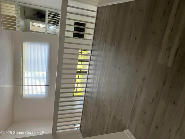 a view of an empty room with wooden floor