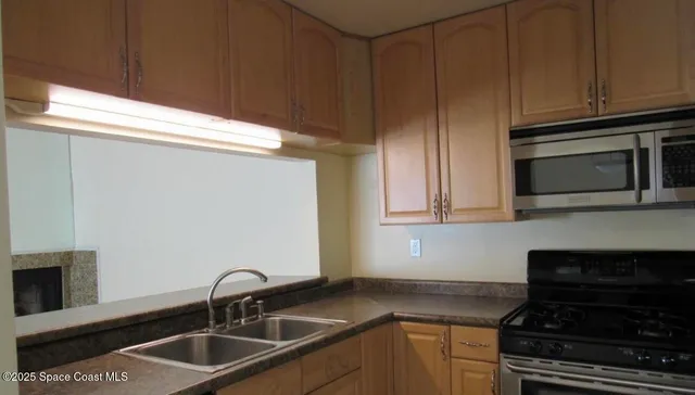 a kitchen with granite countertop a sink stainless steel appliances and cabinets