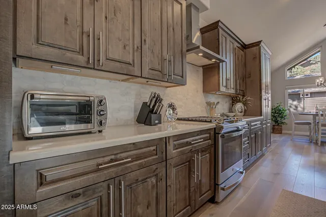 a kitchen with stainless steel appliances granite countertop a sink a stove and cabinets