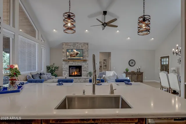 a kitchen with a faucet a chandelier and living room view