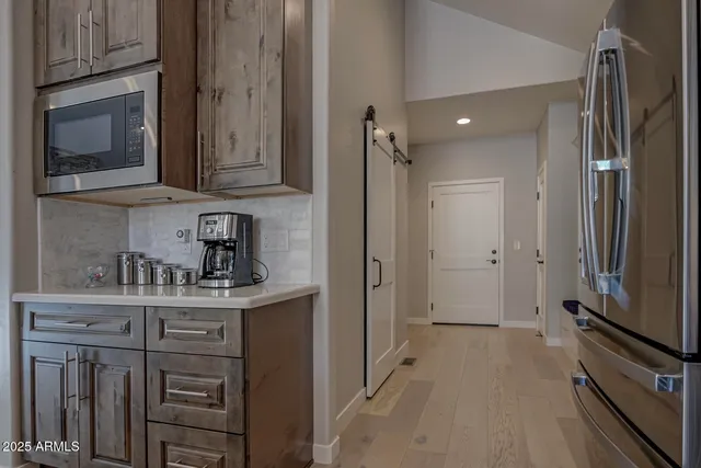 a kitchen with stainless steel appliances granite countertop a refrigerator and a stove top oven