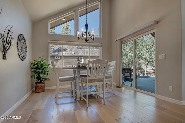 a dining room with furniture potted plants and wooden floor
