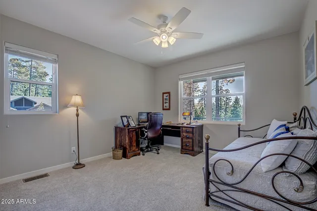 a view of a workspace with furniture and a window