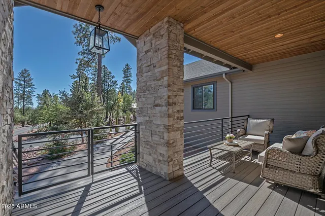 a view of a balcony with two chairs and wooden floor