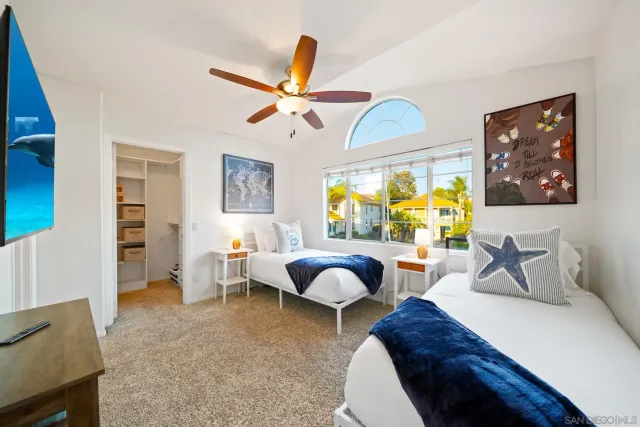 a bedroom with a bed a chair and a potted plant