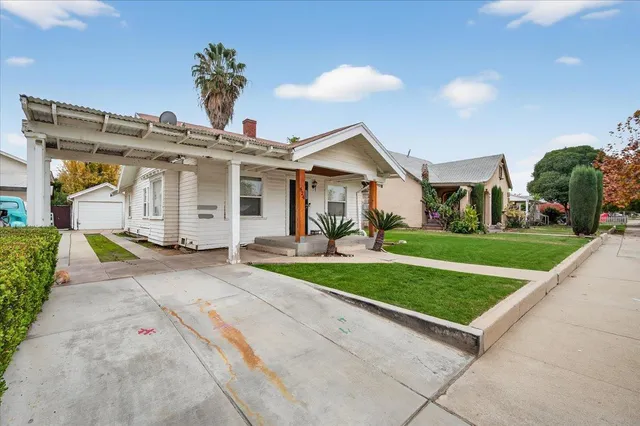 a view of a patio with table and chairs potted plants and a barbeque