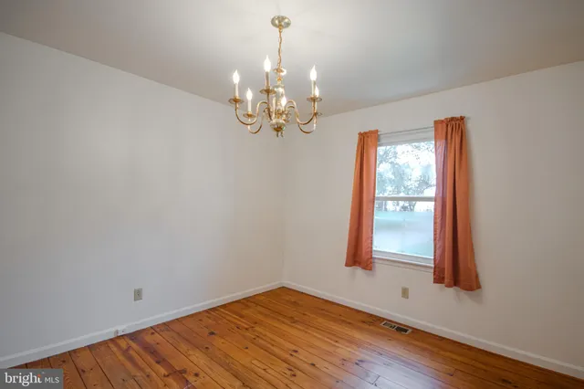 a view of a room with wooden floor and chandelier