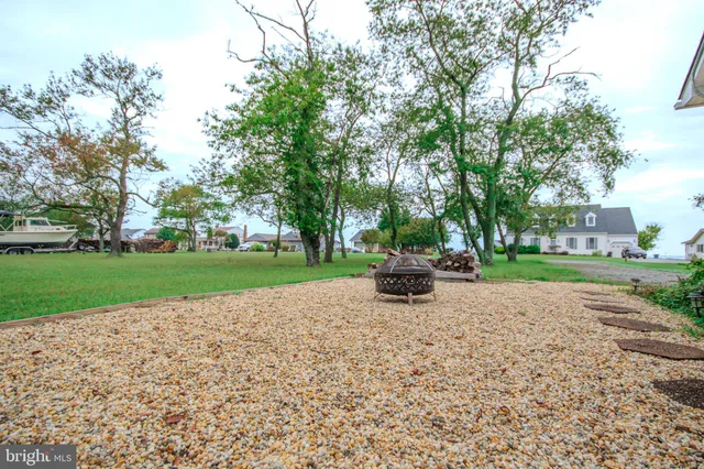 a view of a house with a big yard and large trees