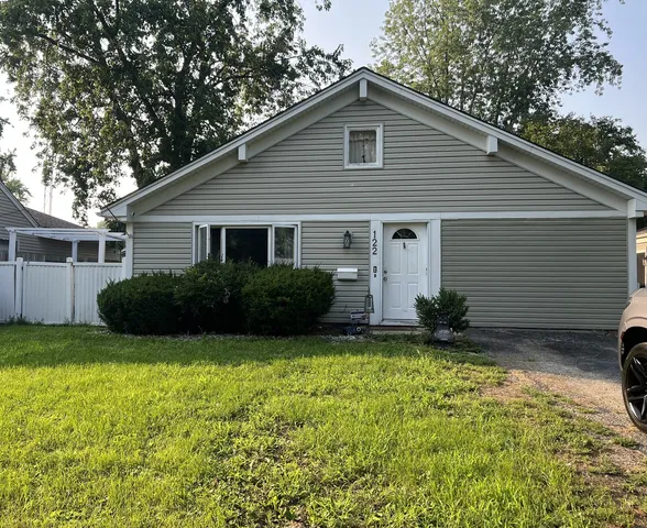 a view of a house with backyard and sitting area