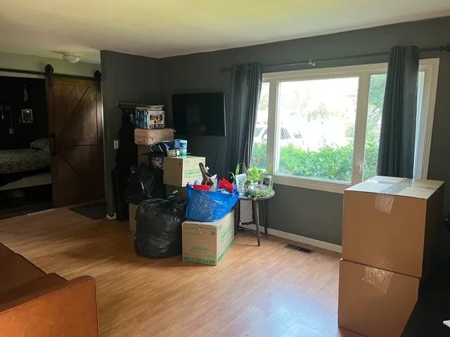 a room with wooden floor and a refrigerator
