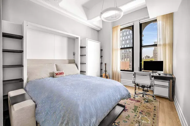 a bedroom with a bed and large windows