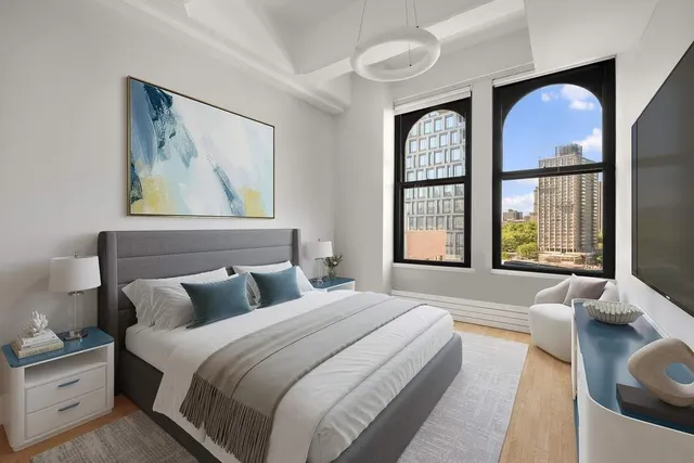 a bedroom with a large bed and windows