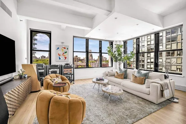 a living room with furniture large windows and a flat screen tv