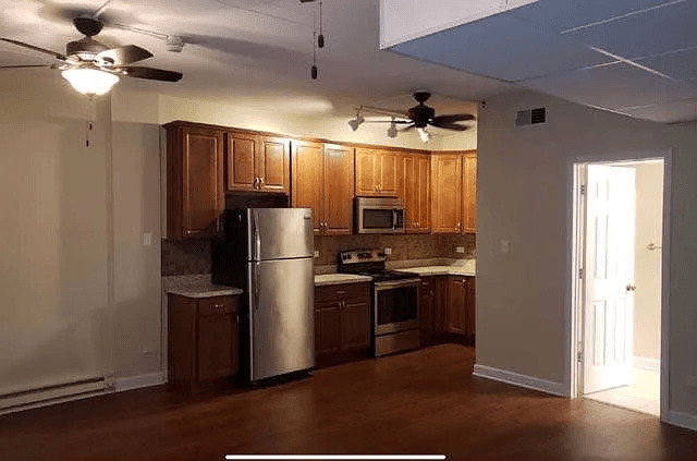 18154 Martin Avenue, Unit 4 Homewood, IL 60430 - Photo 5 of 5 a kitchen with granite countertop stainless steel appliances a refrigerator cabinets and wooden floor