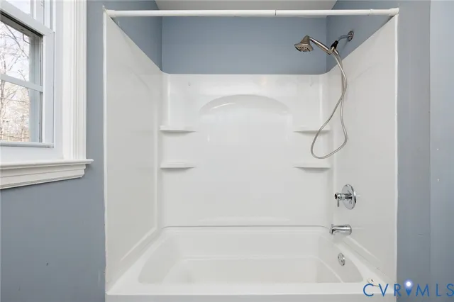 a bathroom with a bath tub with a shower