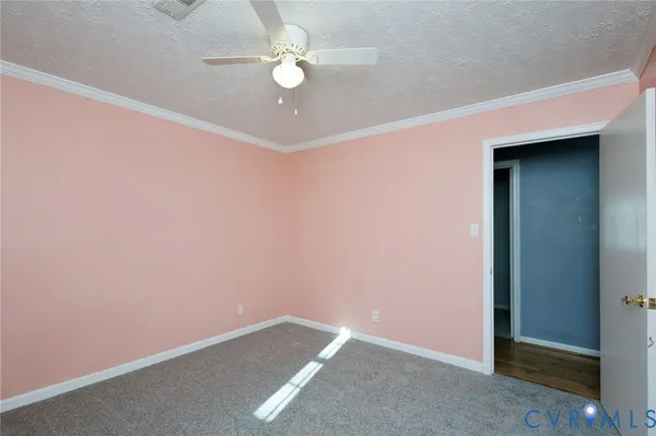 an empty room with a chandelier fan