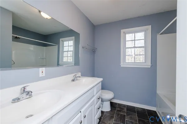 a bathroom with a sink toilet and window