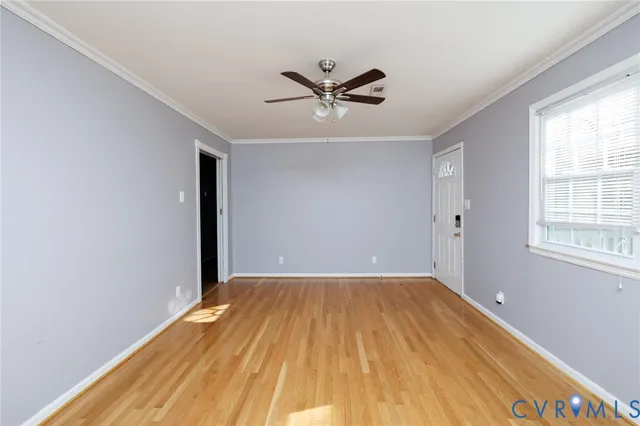 a view of a big room with wooden floor and windows