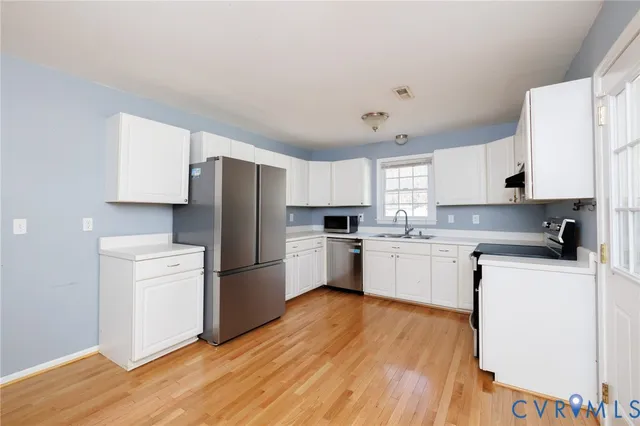 a kitchen with a refrigerator stove top oven and sink