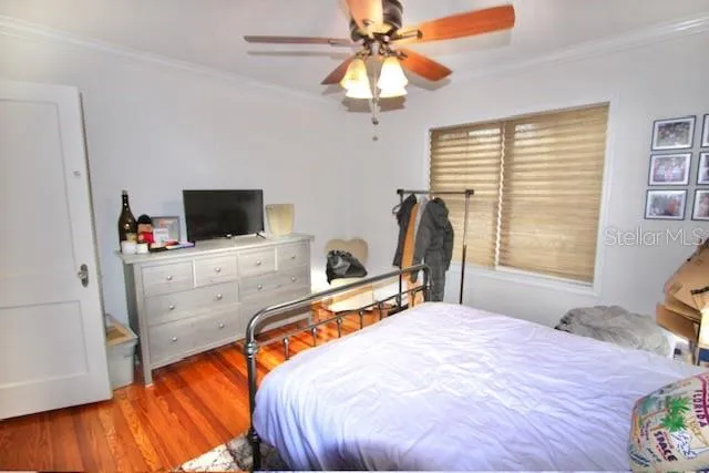 a bedroom with a bed and a flat tv screen on the dresser