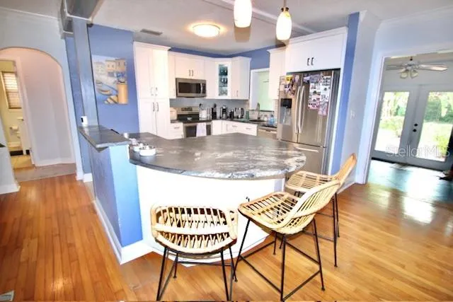 a kitchen with stainless steel appliances granite countertop a dining table chairs and granite counter tops