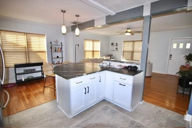 a kitchen with granite countertop a sink stove and cabinets