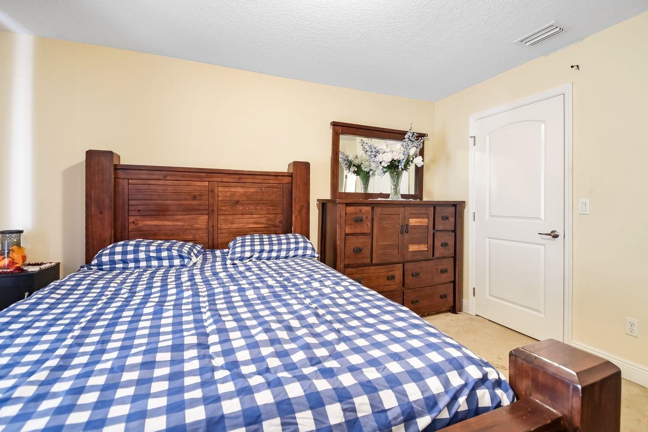 46 Riddle Drive Palm Coast, FL 32164 - Photo 14 of 20 a bedroom with a bed and dresser