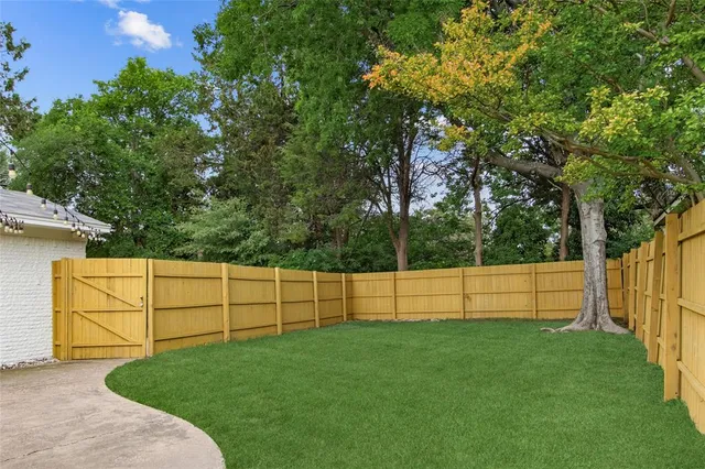 a view of a backyard with a small pool and wooden fence