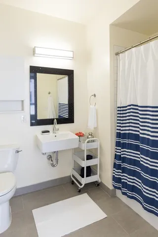 a living room with furniture a chandelier fan and a large window