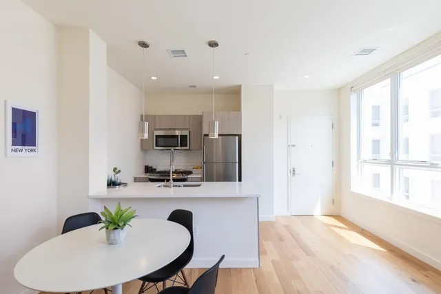 a kitchen with granite countertop a refrigerator and a stove top oven