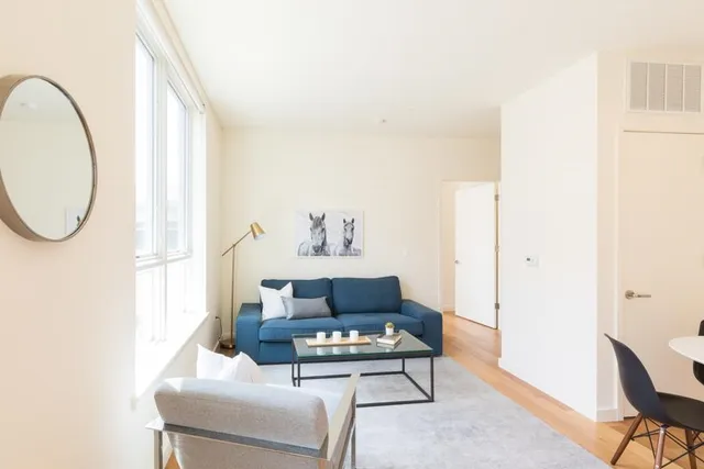 a spacious bedroom with a bed and wooden floor