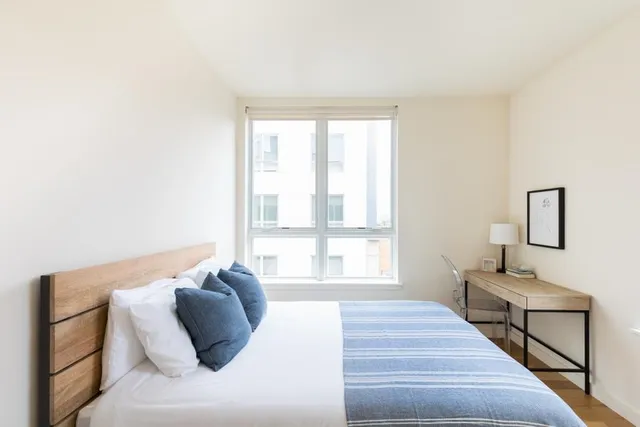 a bedroom with a bed and a window