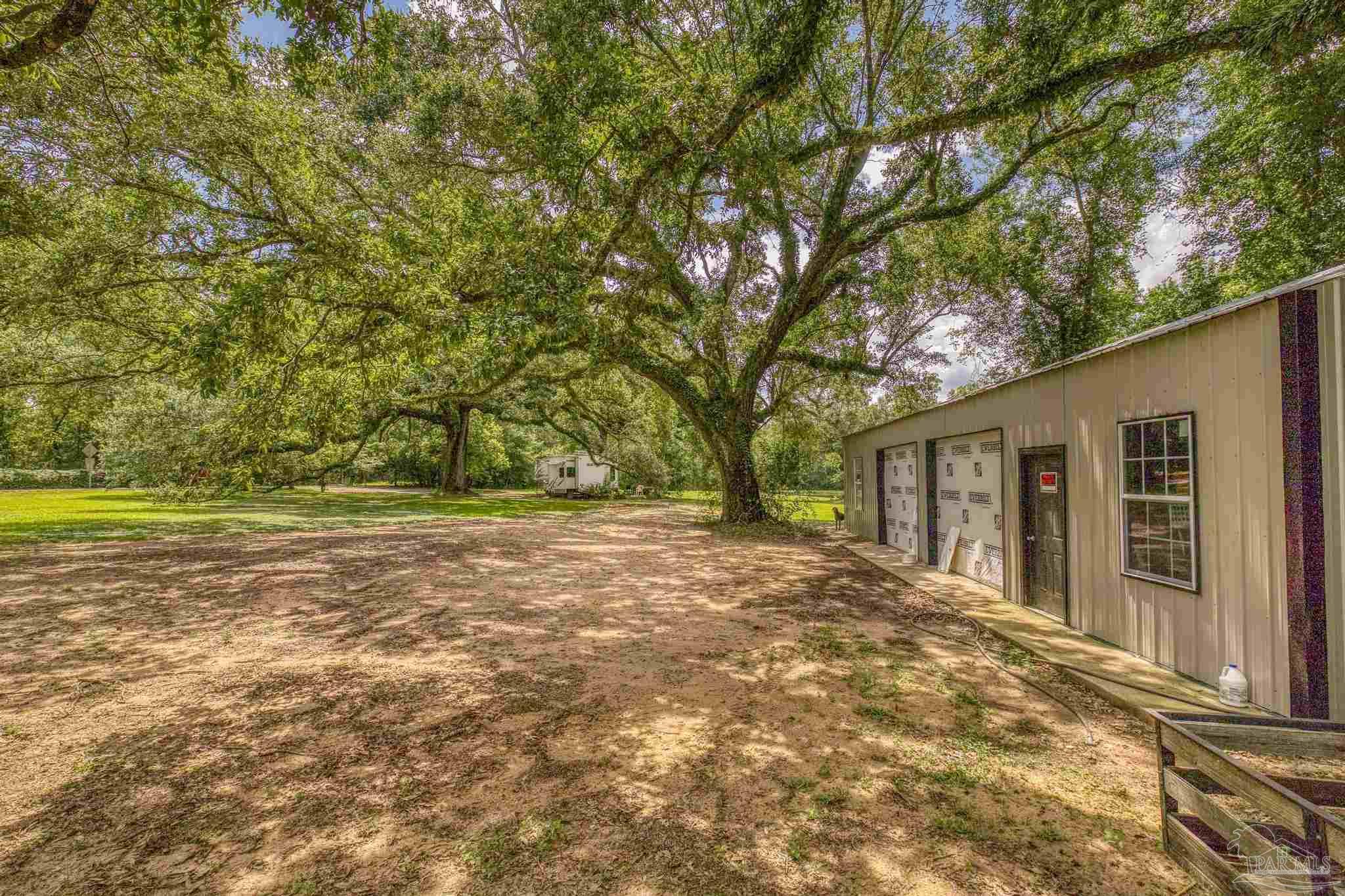 2345 Pompano Street Cantonment, FL 32533 - Photo 6 of 48 a view of a yard with a house and large tree