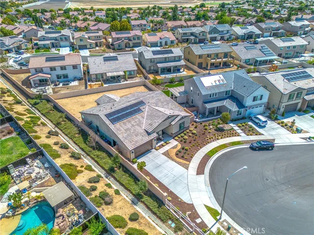 an aerial view of a swimming pool with outdoor seating