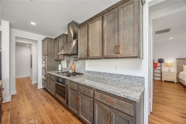 a kitchen with stainless steel appliances granite countertop a stove a sink and a refrigerator