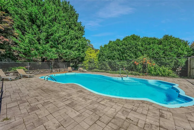 a view of a swimming pool with a yard and sitting area