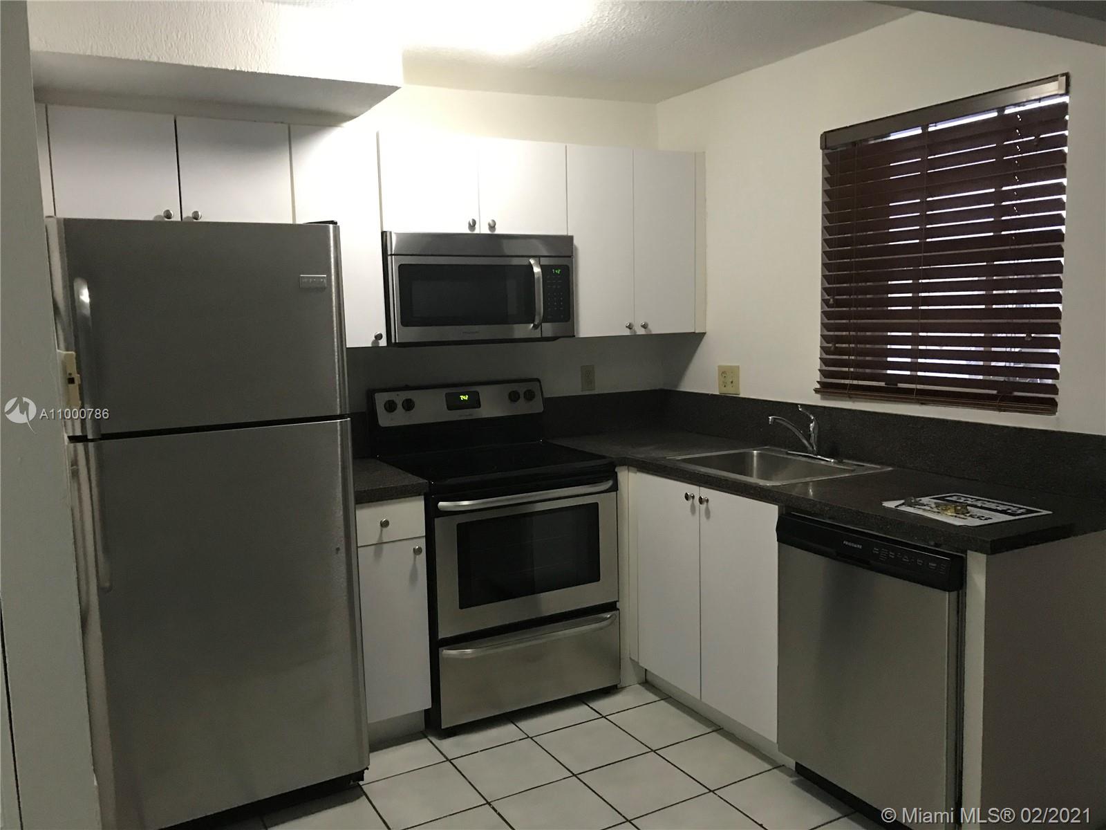 7510 Southwest 152nd Avenue, Unit A208 Miami, FL 33193 - Photo 7 of 9 a kitchen with a refrigerator and a stove top oven