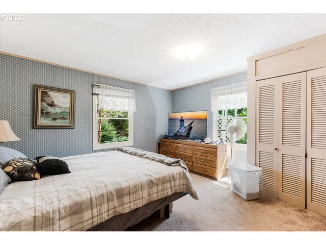 a bedroom with a bed and a large window